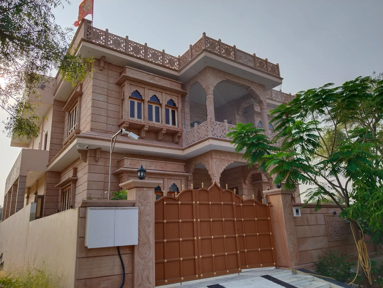 Front exterior, photographed from ground level outside the gate toward the main facade