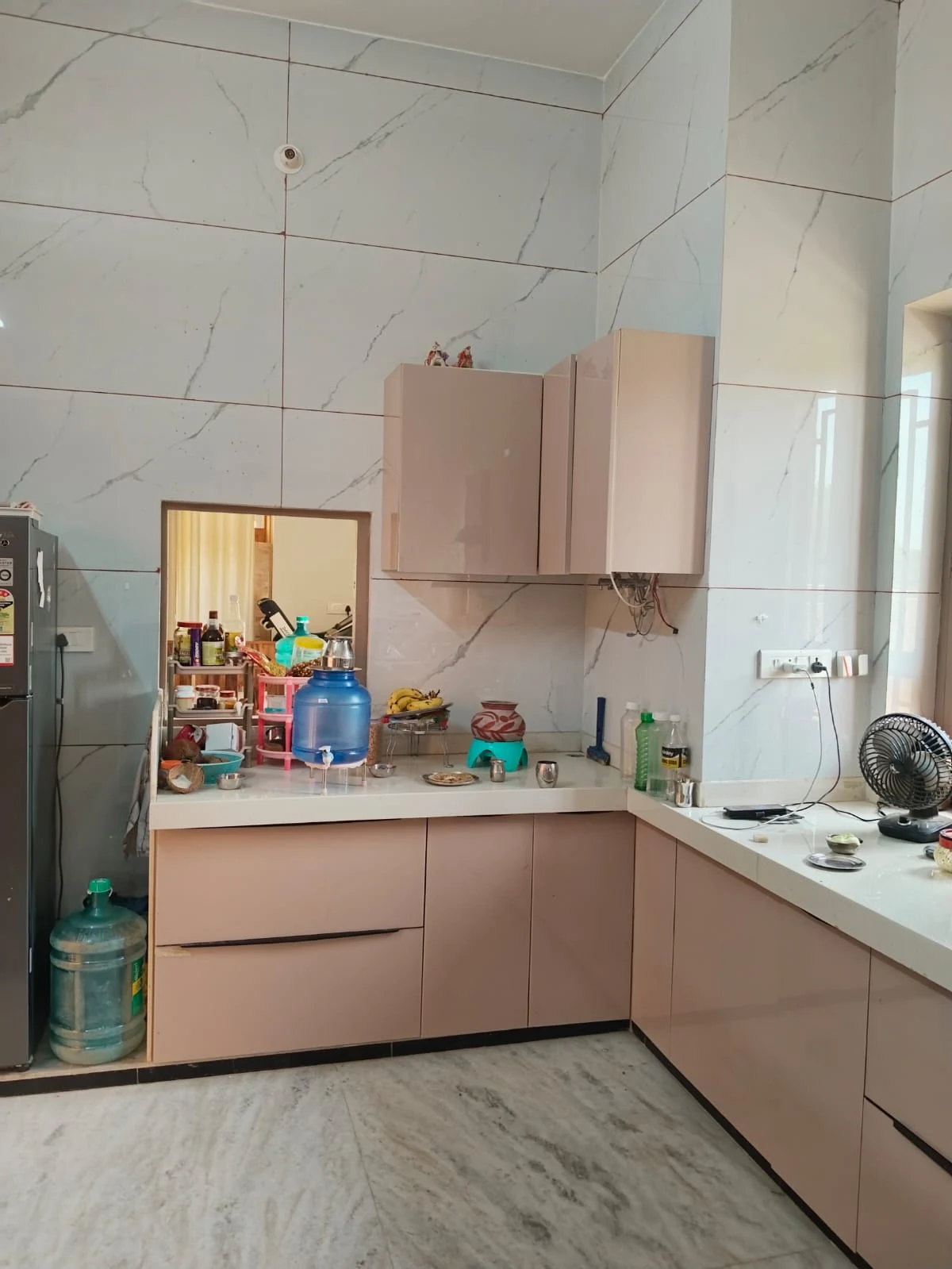 Ground-floor kitchen, from inside toward the countertop and window; entrance is left of the refrigerator